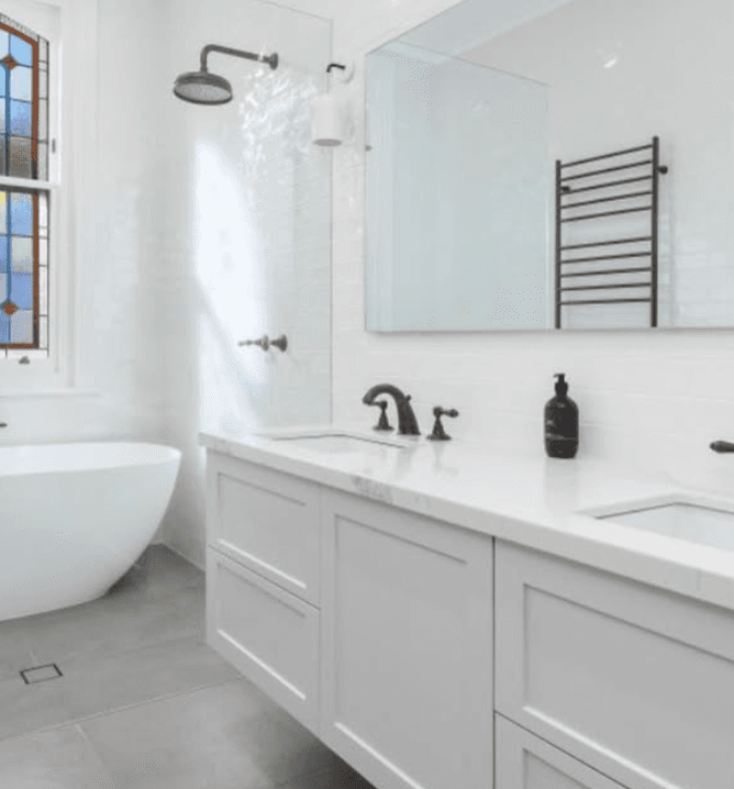 Bright bathroom with floating double vanity and freestanding tub